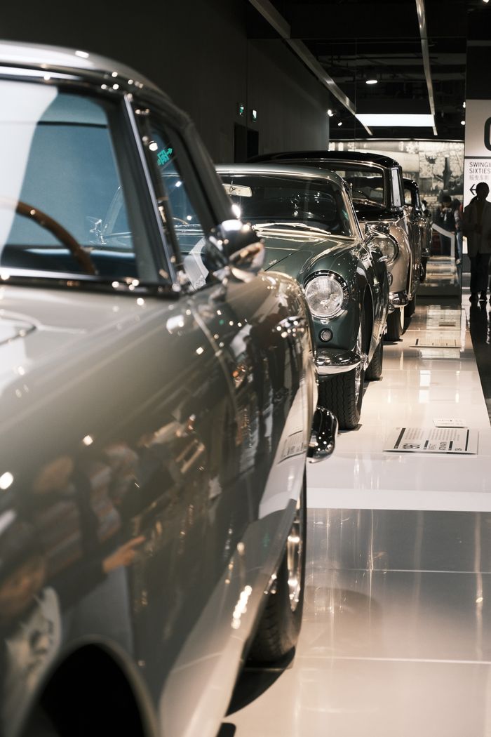 A line of vintage cars showcased in an elegant indoor showroom capturing automotive nostalgia.